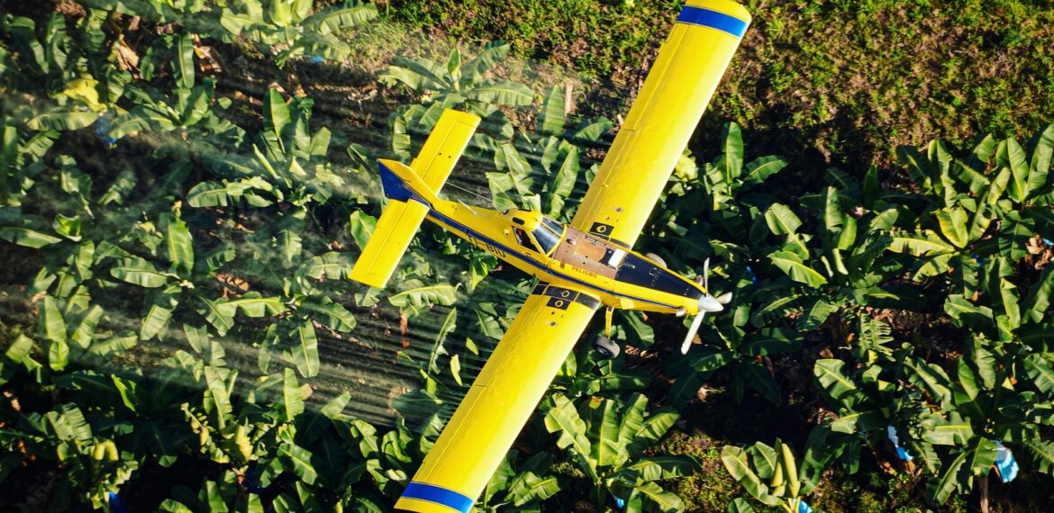 An airplane flighting over banana plantations